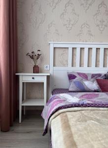 een slaapkamer met een bed en een bijzettafel bij White Deluxe Apartments in Chernihiv