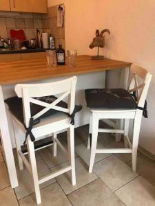 eine Küchentheke mit 2 Stühlen und einem Tisch in der Unterkunft Sunny Swiss mountain Studio in centre by Jolidi in Nendaz