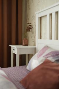 Una cama con una mesa con una maceta. en White Deluxe Apartments, en Cherníhiv