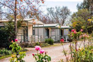 a house with flowers in front of it at Mudgee Riverside Park in Mudgee