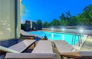 - une piscine avec deux chaises longues à côté d'un bâtiment dans l'établissement Cozy Home In Dugopolje With Jacuzzi, à Dugopolje