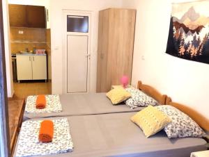 2 camas en una habitación con almohadas de color naranja en Apartment Sandra, en Budva
