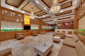 a lobby of a hotel with couches and tables at Anaya Beacon Hotel, Jamnagar in Jamnagar