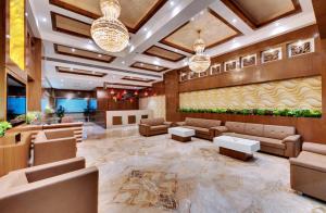 un hall d'un hôtel avec des canapés et des tables dans l'établissement Anaya Beacon Hotel, Jamnagar, à Jamnagar