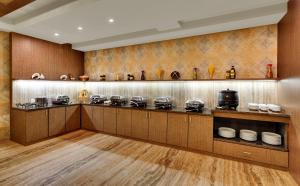a kitchen with a counter with many pots and pans at Anaya Beacon Hotel, Jamnagar in Jamnagar