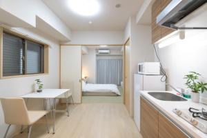 eine kleine Küche und ein Esszimmer mit einem Tisch und einem Waschbecken in der Unterkunft Rewitビル in Osaka