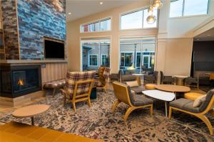 a lobby with tables and chairs and a fireplace at Residence Inn Upper Marlboro Joint Base Andrews in Capitol Heights