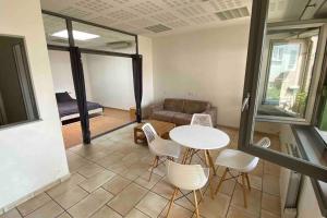 a living room with a table and chairs and a couch at T2 idéalement situé in Thonon-les-Bains