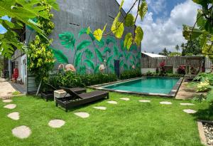 una piscina en un patio con un mural en Kenan Cottage, en Canggu