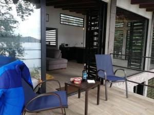 un patio con 2 sillas, una mesa y un sofá en Zirahuen, cabaña moderna junto al lago, en Zirahuén