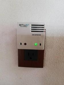 un dispositivo electrónico con luz verde en una pared en Zirahuen, cabaña moderna junto al lago, en Zirahuén