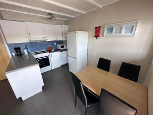 uma cozinha com mesa e cadeiras num quarto em Nautnes Seaside Apartments A3 em Nautnes