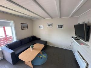 a living room with a couch and a table and a tv at Nautnes Seaside Apartments A3 in Nautnes