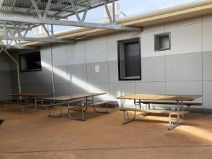 a room with two tables and a wall with windows at Inspirations Mullewa in Mullewa