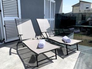 3 Stühle mit Hüten auf einer Terrasse in der Unterkunft Deluxe Suites Anna in Vodice