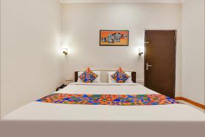 A bed or beds in a room at FabHotel Shri Laxmi Palace