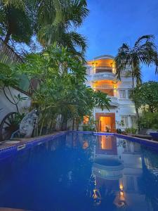 a hotel with a swimming pool in front of a building at Villa Um Theara, Siem Reap in Siem Reap