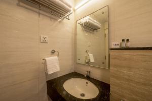 a bathroom with a sink and a mirror at Olive Hotel Electronic City by Embassy Group in Bengaluru