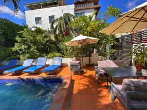 - Piscina con sillas, mesa y sombrilla en Villa Um Theara, Siem Reap, en Siem Reap