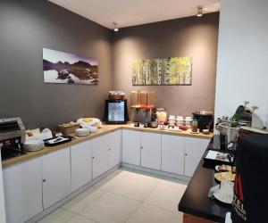 a kitchen with white cabinets and a counter with food at M Hotel Jakarta in Jakarta