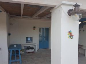 a porch with a blue door and a blue stool at Dimora Grecale in Cisternino
