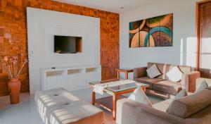 a living room with a couch and a tv at Bale Gede Luxury Villas in Seminyak