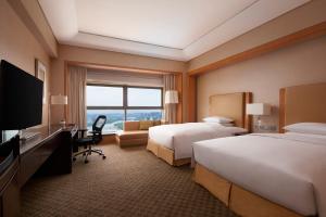 a hotel room with two beds and a flat screen tv at Ningbo Marriott Hotel in Ningbo