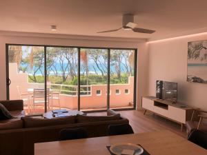 a living room with a couch and a large window at Camargue Beachfront Apartments in Maroochydore