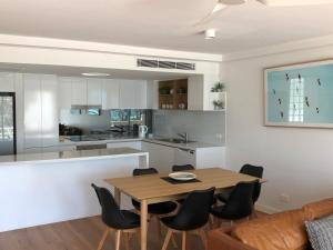 a kitchen and dining room with a wooden table and chairs at Camargue Beachfront Apartments in Maroochydore