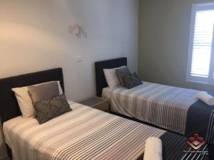 a bedroom with two beds and a window at Camargue Beachfront Apartments in Maroochydore