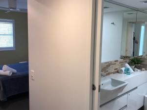 a bathroom with a sink and a mirror at Camargue Beachfront Apartments in Maroochydore