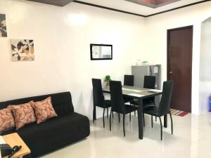 a dining room with a table and chairs and a couch at Lemon Transient House Puerto Princesa Palawan in Puerto Princesa City