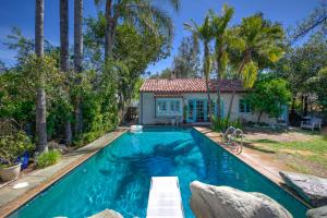 - une piscine en face d'une maison avec des palmiers dans l'établissement The Gabrielino Trail House, à Altadena