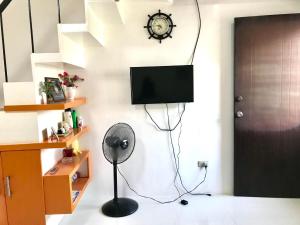 a room with a fan and a tv on a wall at Lemon Transient House Puerto Princesa Palawan in Puerto Princesa City