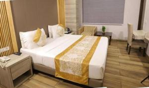 a hotel room with a large bed and a desk at FabHotel Prime Anchorage in New Delhi