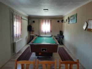 a room with a pool table and two chairs at Váradi Apartman in Abádszalók