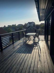 a wooden deck with a table and chairs on a balcony at Nautnes Seaside Villa in Nautnes
