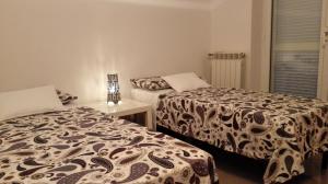 a bedroom with two beds and a table and a window at La Zucca a Pois in Formia