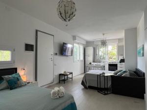 a bedroom with a bed and a living room at Beach Loft Poetto in Quartu SantʼElena
