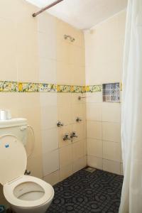 a bathroom with a toilet and a shower at Sea Breeze Village, Baga Goa in Calangute