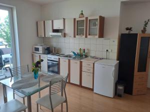 een keuken met een tafel en stoelen en een koelkast bij apartmán Peškova in Olomouc