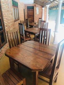 a group of wooden tables and chairs in a room at Komaligma villa by camrin Group 