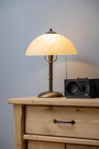 a lamp on top of a dresser with a radio at Atmospheric Studio Zakopane next to Krupówki by Renters in Zakopane