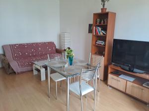 een woonkamer met een tafel en stoelen en een televisie bij apartmán Peškova in Olomouc