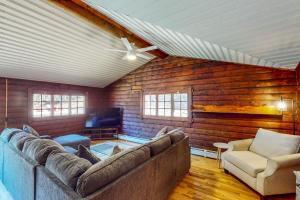ein Wohnzimmer mit einem Sofa und einem Stuhl in der Unterkunft Hawks Eye Cabin in Otis