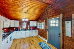een keuken met witte kasten en een blauwe deur bij Hawks Eye Cabin in Otis