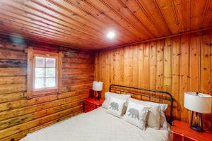 een slaapkamer met een bed in een houten muur bij Hawks Eye Cabin in Otis