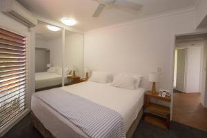 um quarto com uma grande cama branca e uma janela em Beaches No 4 - Absolute Beachfront em South Mission Beach