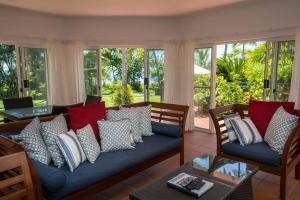 uma sala de estar com um sofá azul com almofadas em Beaches No 4 - Absolute Beachfront em South Mission Beach