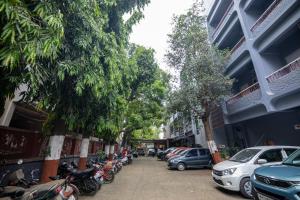 a street with cars and motorcycles parked next to buildings at Hotel Rama Heritage in Nashik